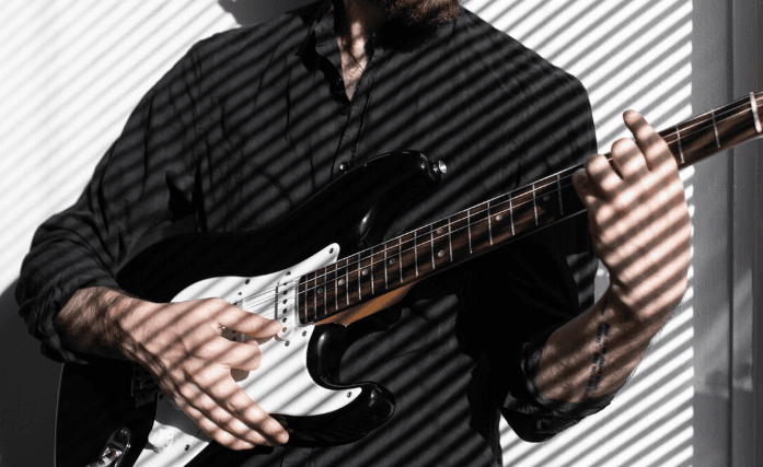 Músico con eléctrica en un escenario con luces tenues