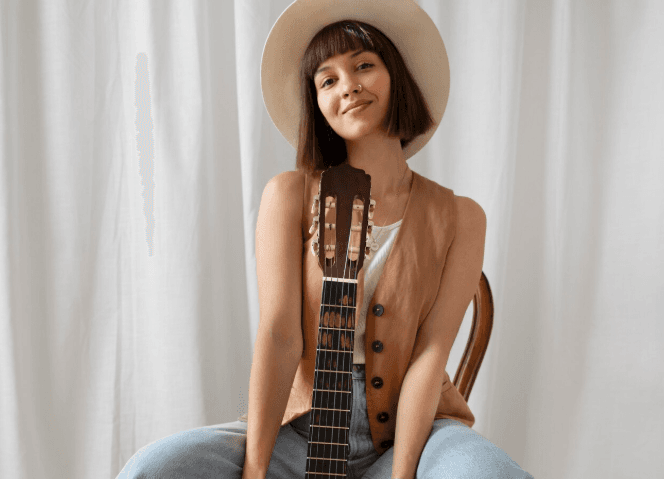 Persona tocando acústica en un ambiente íntimo