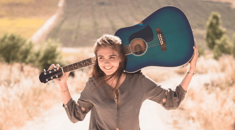 Persona concentrada tocando una guitarra acústica